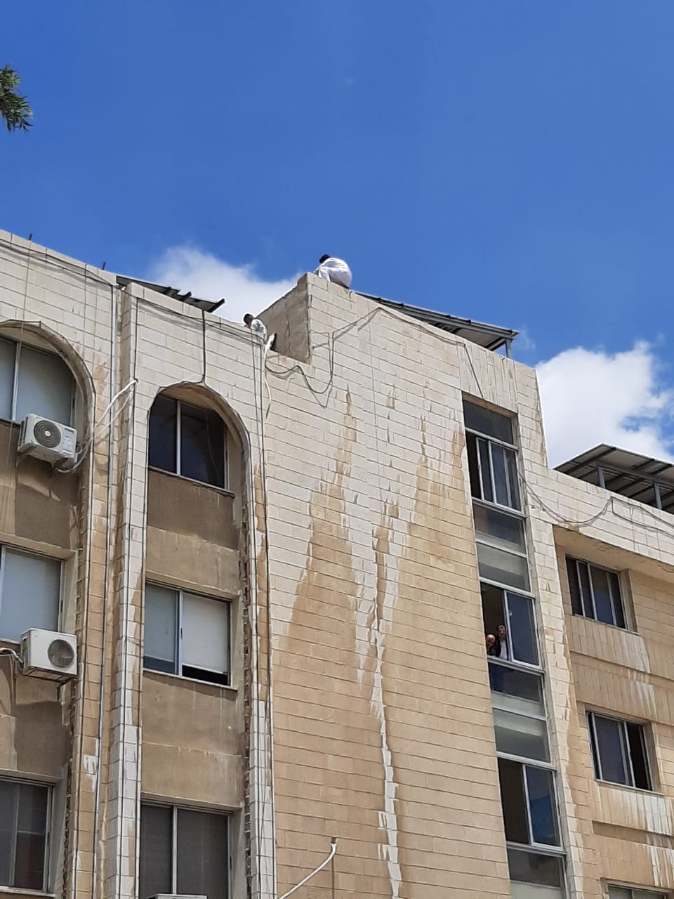 مواطن يهدد بالانتحار من فوق مبنى وزارة الاوقاف... صور
